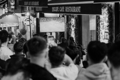 Πλήθος παρακολουθεί αγώνα ποδοσφαίρου σε γιγαντοοθόνη τη νύχτα